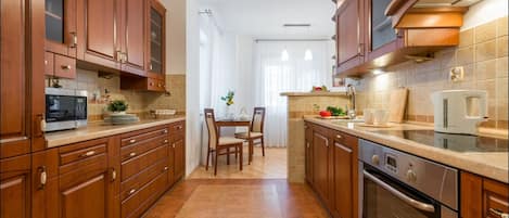 Economy appartement | Privékeuken | Een koelkast, een magnetron, een oven, een kookplaat