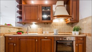 A kitchen with wooden cabinets, a built-in oven, and a sink. - P&O Apartments Grodkowska (Warsaw)