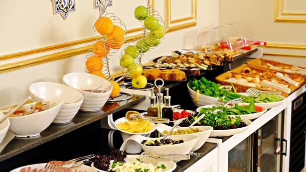 A buffet with various food items, including fruits, salads, and meats. - Hotel Kralice (Istanbul)