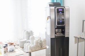 Una cafetera con pantalla digital y dispensador de agua.