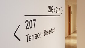 A hallway with a sign indicating the direction to the terrace and breakfast area. - Santa Teresa House (Verona)