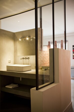 A modern bathroom with a large mirror, a white sink, and a glass partition. - L'Esprit des Chartrons (Bordeaux)