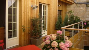 Un bâtiment en bois doté d’un balcon, d’une plante en pot et d’un escalier.