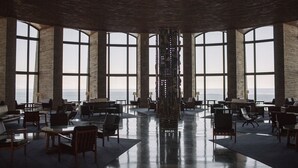 A spacious lobby with large windows, a central column, and multiple seating areas. - Apartaments Cap Sa Sal (Begur)