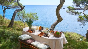 A table set for a meal with a view of the sea. - Apartaments Cap Sa Sal (Begur)