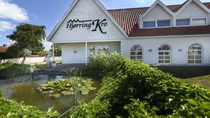 A white building with a peaked roof and a sign reading "Hjørring Kro". - Hjørring Kro (Hjørring)