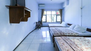 Habitación de hotel con dos camas, un escritorio y una silla.