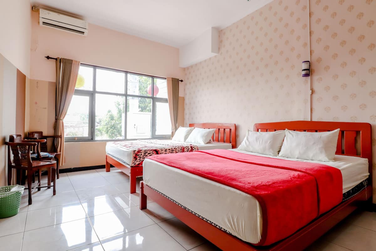 A hotel room with two beds, a desk, and a chair.