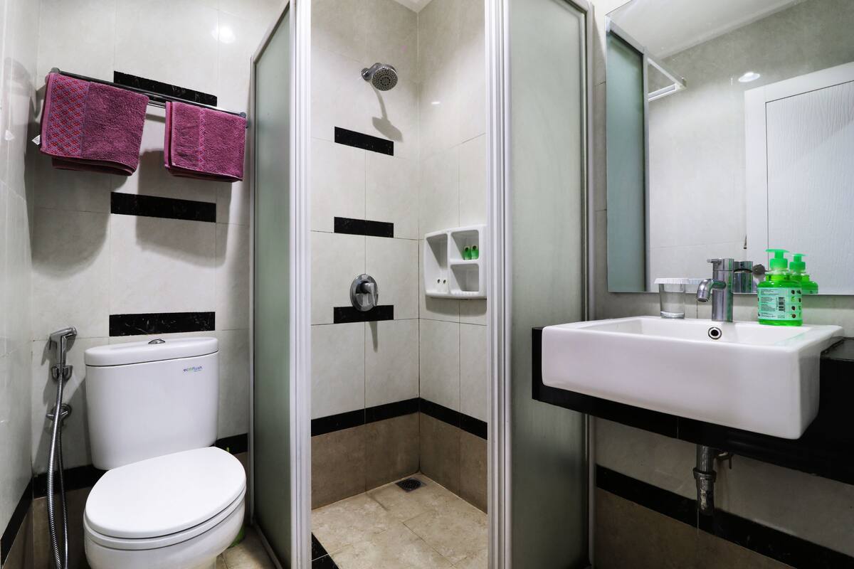 A modern bathroom with a toilet, shower, and sink.