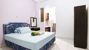 Ein Schlafzimmer mit Bett, Kleiderschrank und Spiegel.