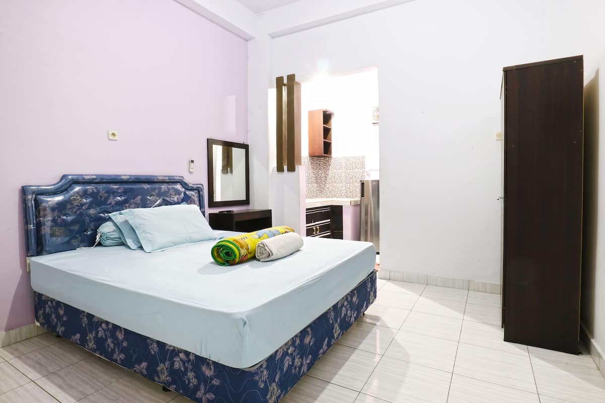 Un dormitorio con cama, armario y espejo.