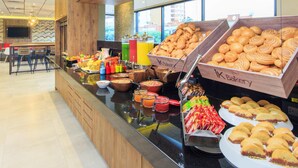 Ein Buffet mit verschiedenen Speisen und einem Schild mit der Aufschrift 'ik Bakery'.