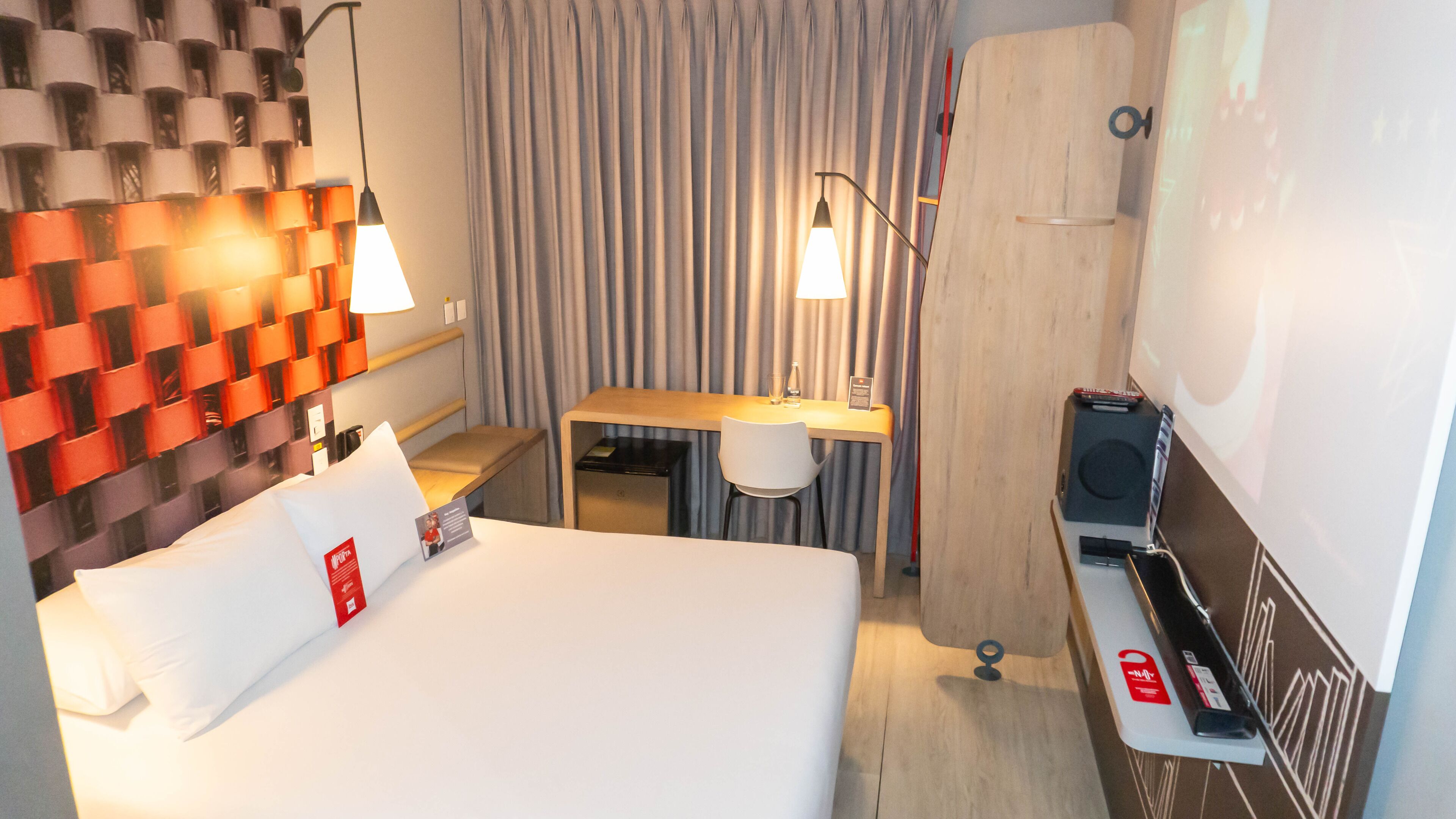 Une chambre d’hôtel équipée d’un lit, d’un bureau, d’une chaise et d’un téléviseur.