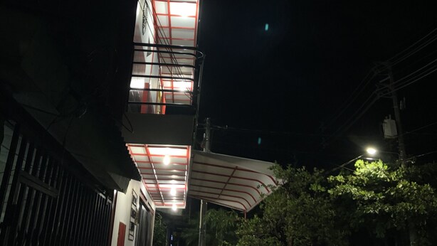 Ein mehrstöckiges Gebäude mit einer zentralen Treppe und einem überdachten Außenbereich.