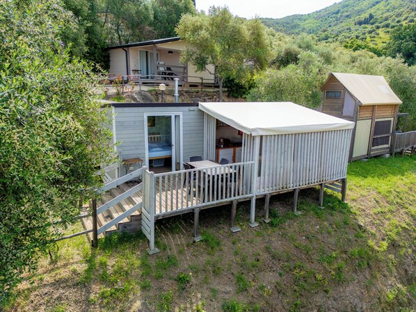 A small cabin with a balcony, a deck, and a kitchen area. - Vallicella Glamping Resort (Scarlino)