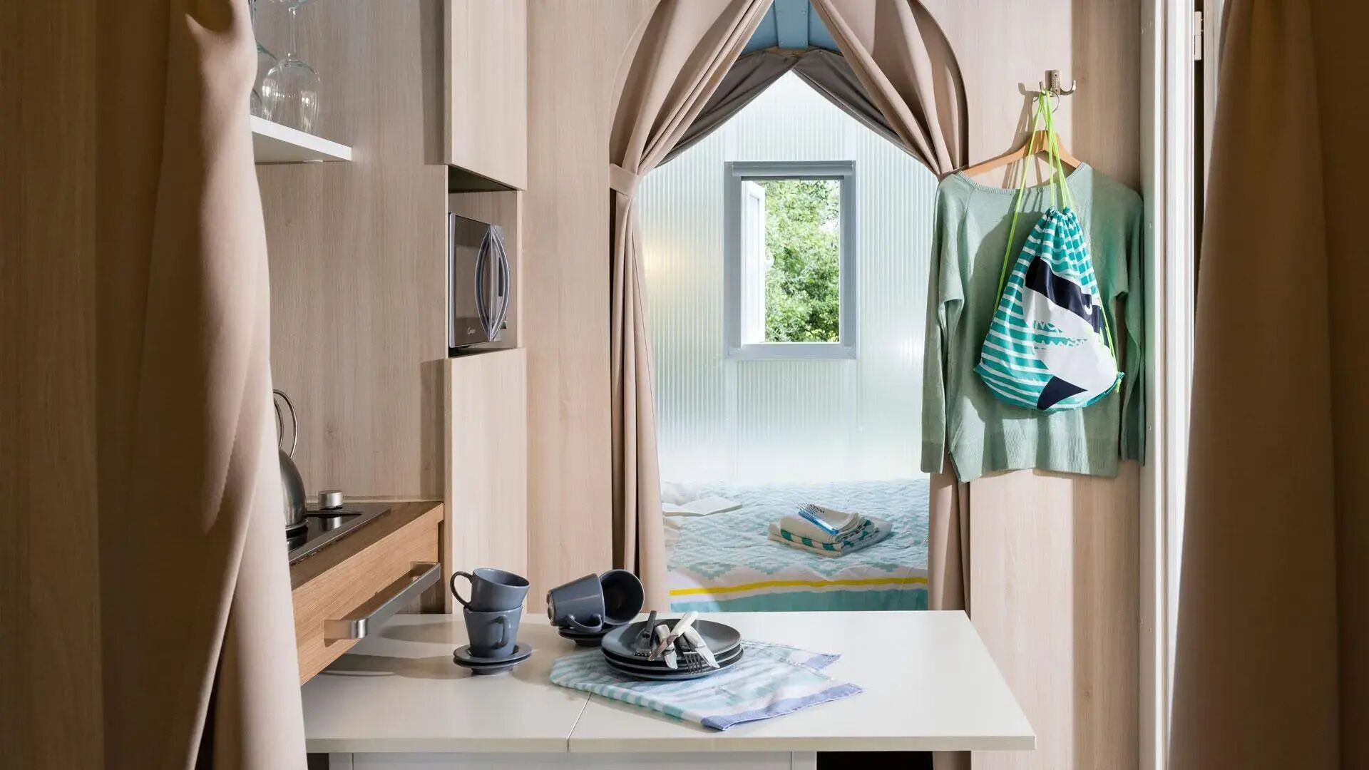 A bedroom with a bed, a window, and a view of greenery outside.