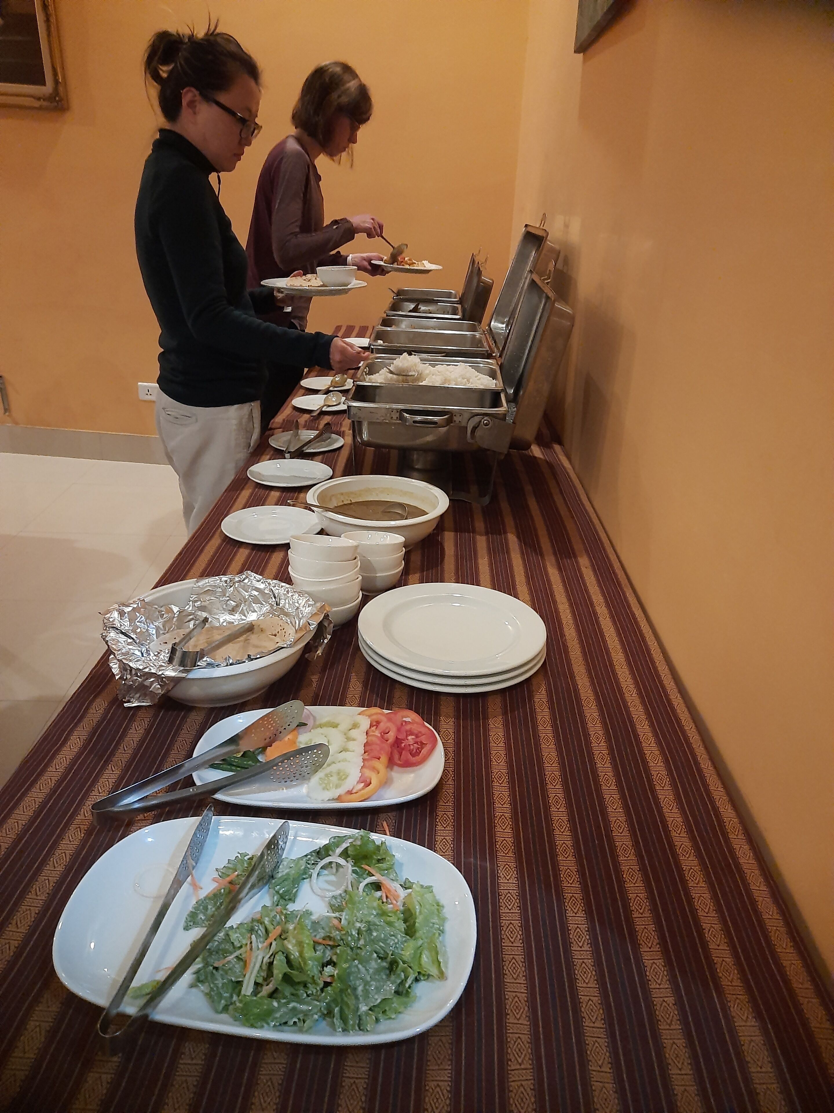 Un buffet avec différents plats et ustensiles disposés sur une table.