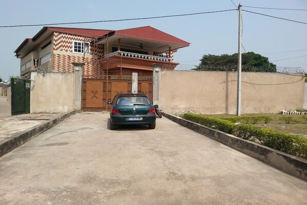 A two-story building with a red roof and a gated entrance.