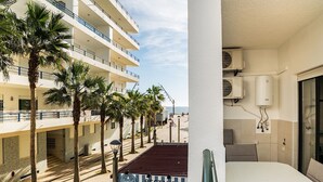 Ein Balkon mit Blick auf Palmen und ein Restaurant.