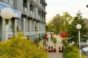 A multi-story building with balconies, a parking area, and potted plants. - Hotel One Jinnah (Islamabad)