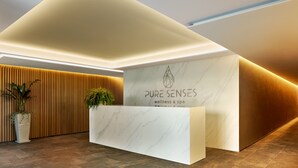 A reception desk with a marble top and a logo that reads "PURE SENSES wellness & spa". - Hotel Apartamentos Dunamar (Vila Real Santo Antonio)
