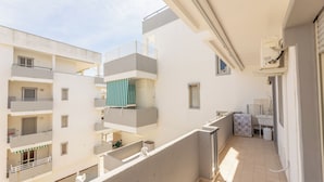 A multi-story residential building with balconies, a visible laundry area, and a window with a towel hanging outside. - Case Vacanza Rivabella (Gallipoli)