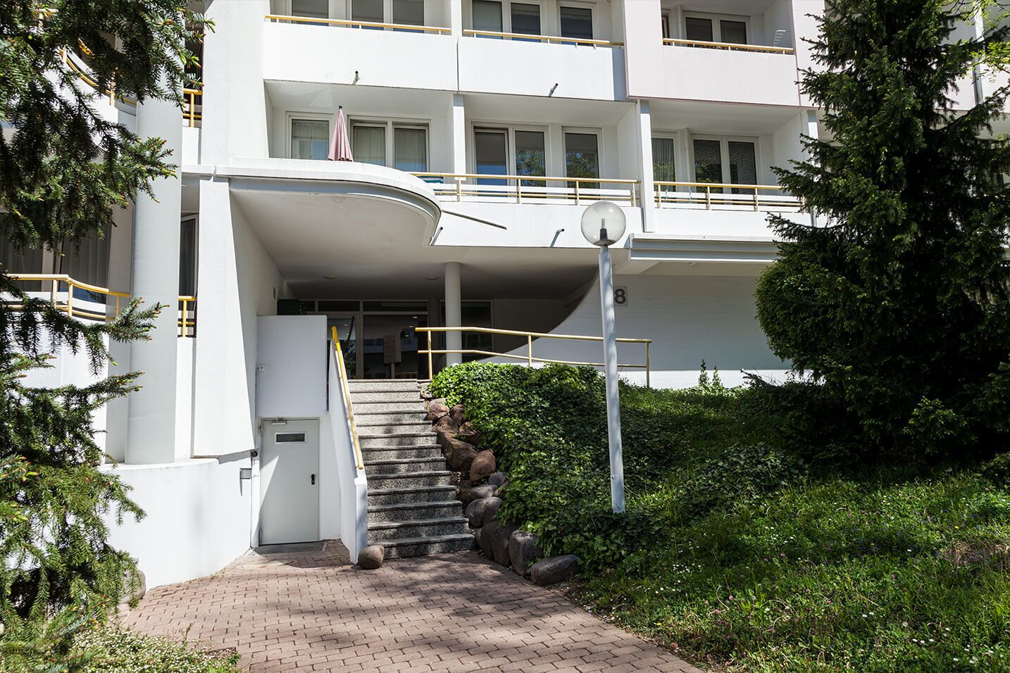 A multi-story building with a central staircase leading to a landing.