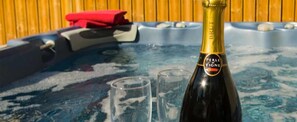 A hot tub with a bottle of champagne and two glasses. - Chalet Cœur des Brévières by Chalet Chardons (Tignes)