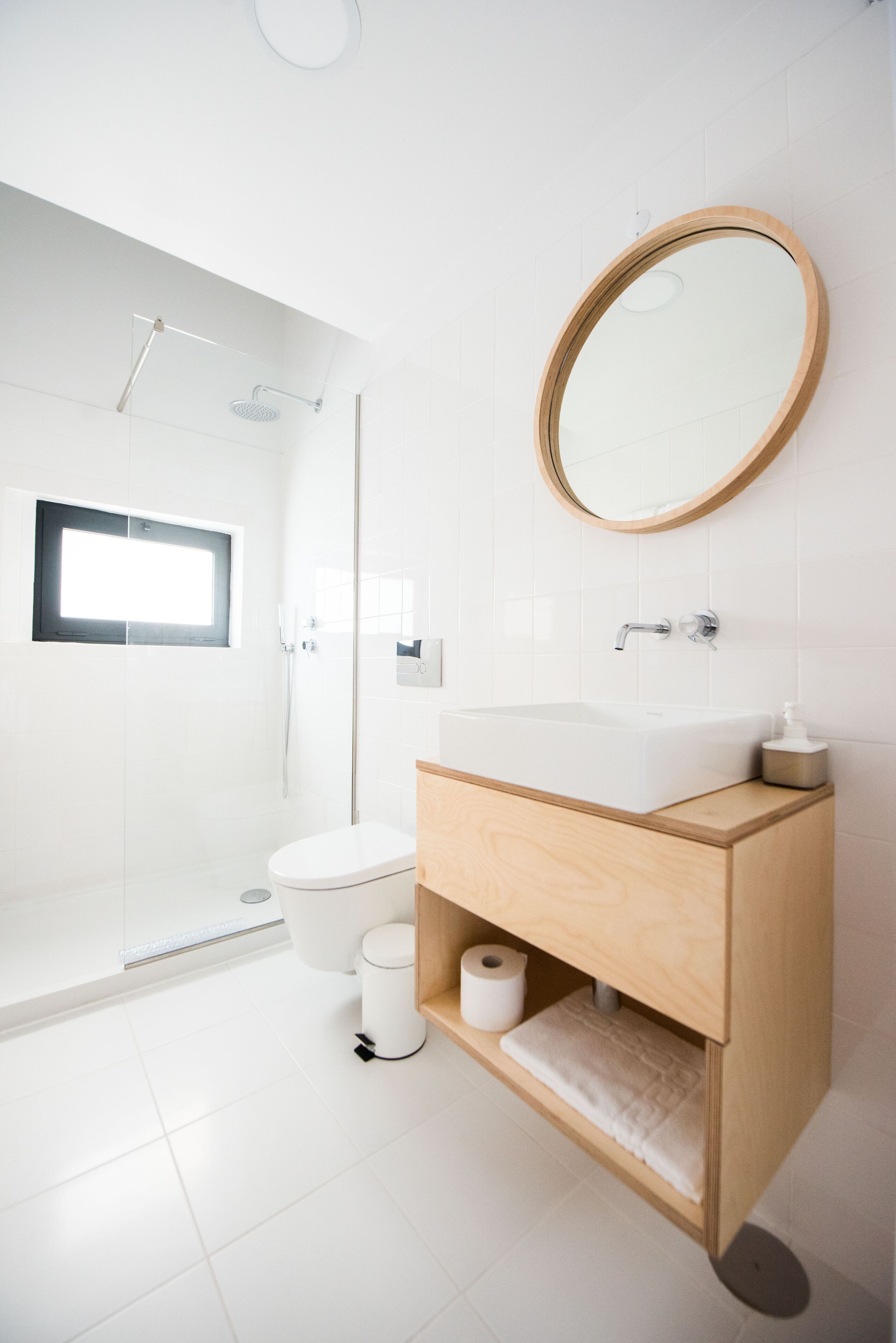 A modern bathroom with a shower, toilet, and sink.