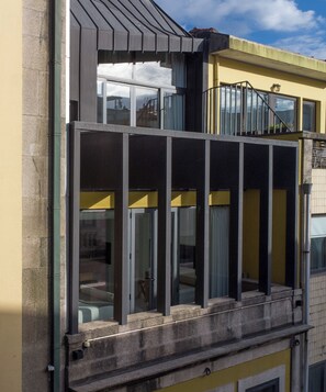A building with a balcony, large windows, and a yellow facade. - I Loft Porto (Porto)