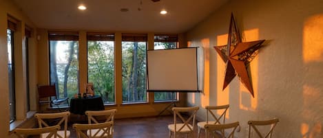 A conference room with a whiteboard, wooden chairs, a table with a laptop, and a star decoration on the wall.