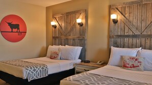 A hotel room with two beds, a wooden headboard, a red circular sign, and a nightstand with a phone.
