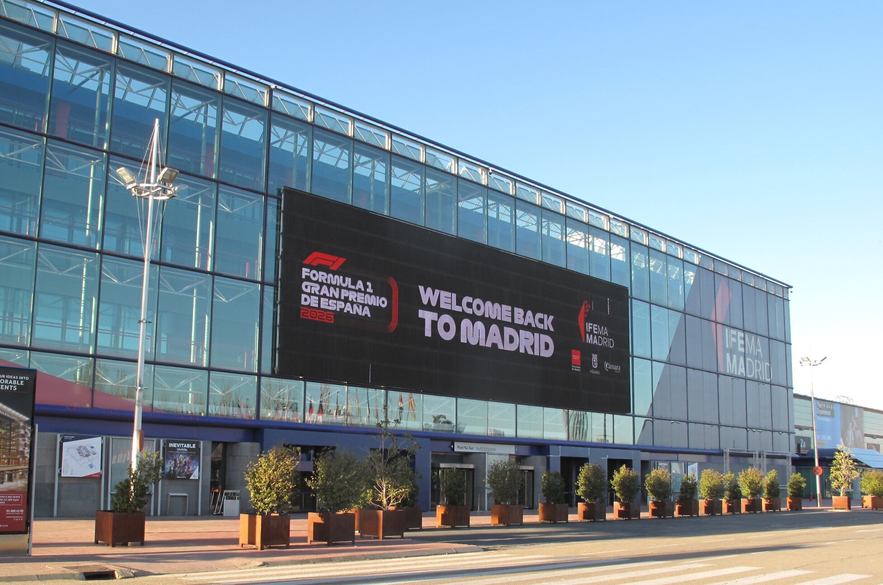 A modern building with a large billboard welcoming visitors to Madrid for the Formula 1 Grand Prix.