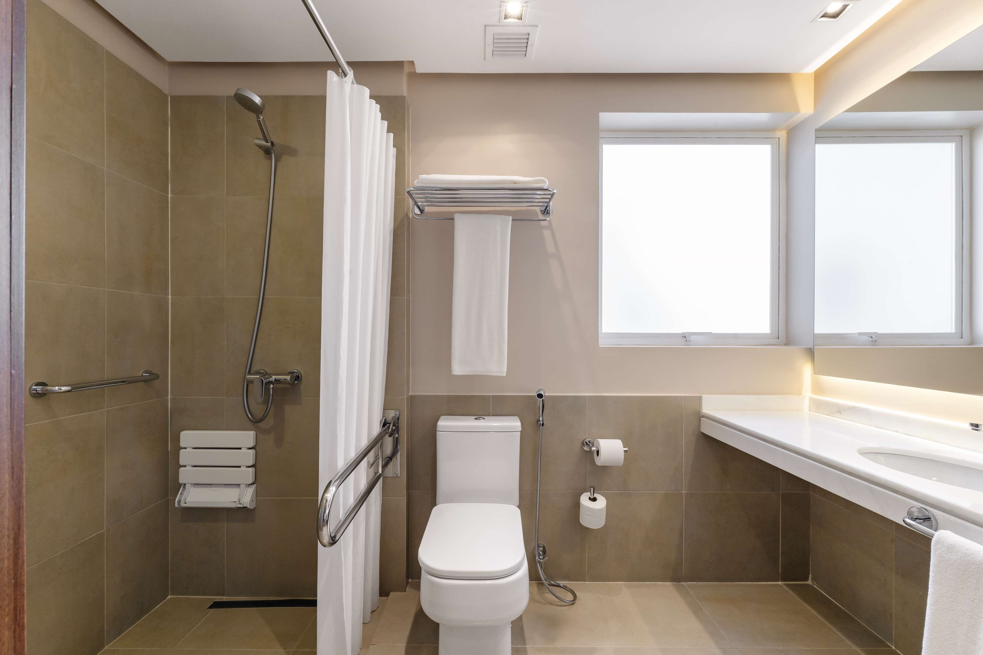 A modern bathroom with a shower, toilet, and sink.