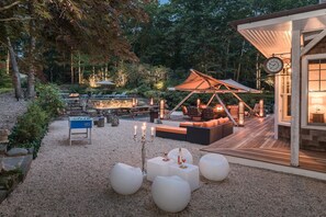 En utomhusplats med en uteplats, sittplatser, ett bord och en pergola.