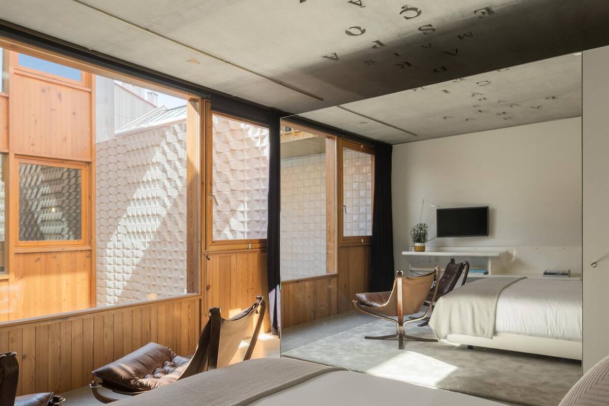 Un dormitorio moderno con una cama grande, un escritorio y un televisor.