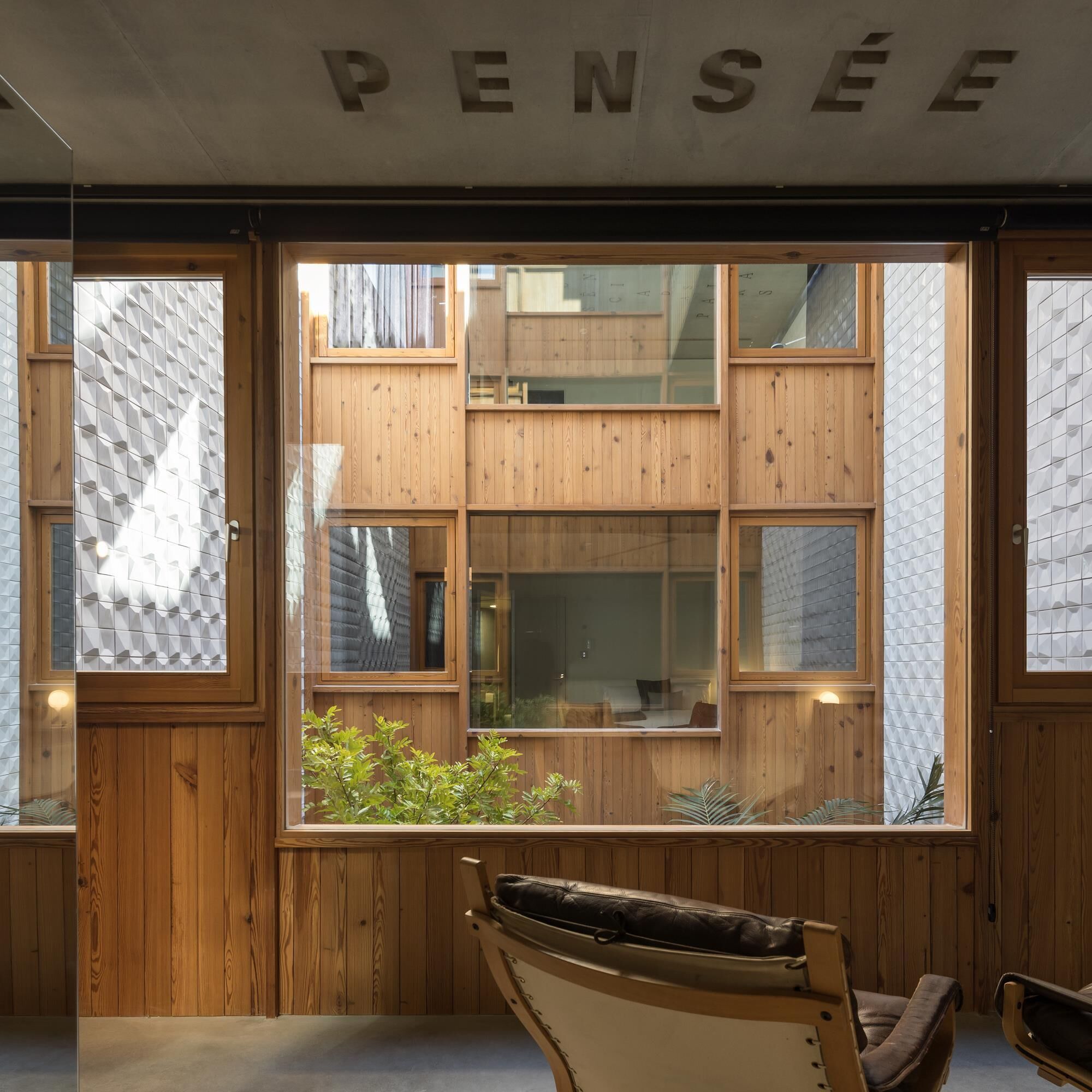 A modern interior with wooden paneling and large windows.