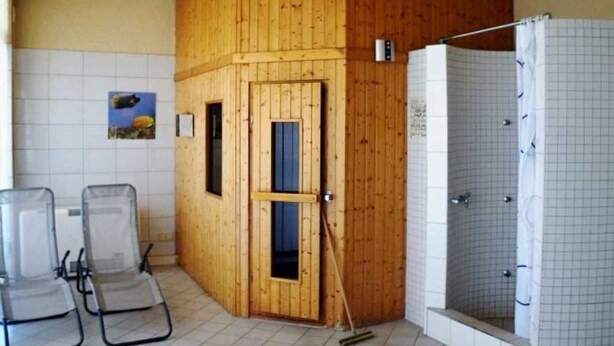 A sauna room with wooden walls, a shower, and two lounge chairs. - 2-room apartment - House Quisisana - Apartment 45496 (Göhren)