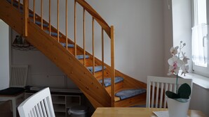 A staircase with wooden railings and blue carpeted steps leading to a landing. - 2-room apartment - House Quisisana - Apartment 45496 (Göhren)