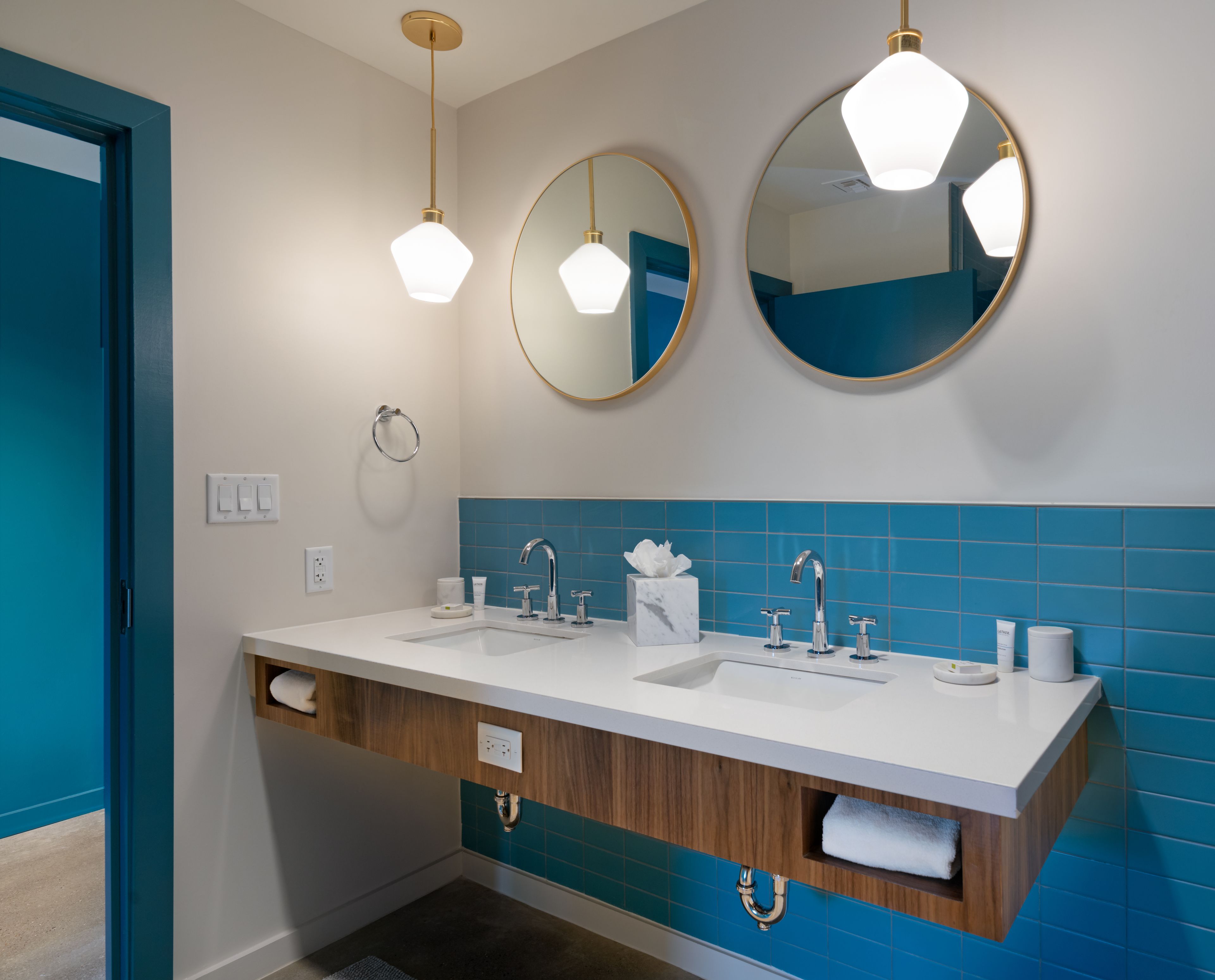Une salle de bain moderne avec deux lavabos, un miroir et un porte-serviettes.
