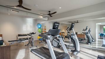 A modern gym with treadmills, stationary bikes, and free weights.