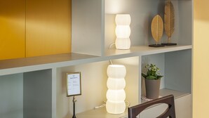 A modern interior with a multi-tiered light fixture, a framed sign, and a potted plant on a shelf. - CdC Apartments By Casa do Conto (Porto)