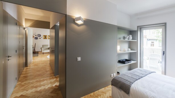 A bedroom with a bed, a wardrobe, a bedside table, and a window. - CdC Apartments By Casa do Conto (Porto)