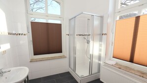 Un baño con ducha, lavamanos e inodoro.