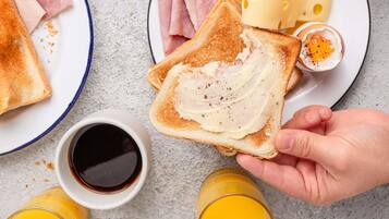 A breakfast setting with toast, cheese, ham, and a cup of coffee.