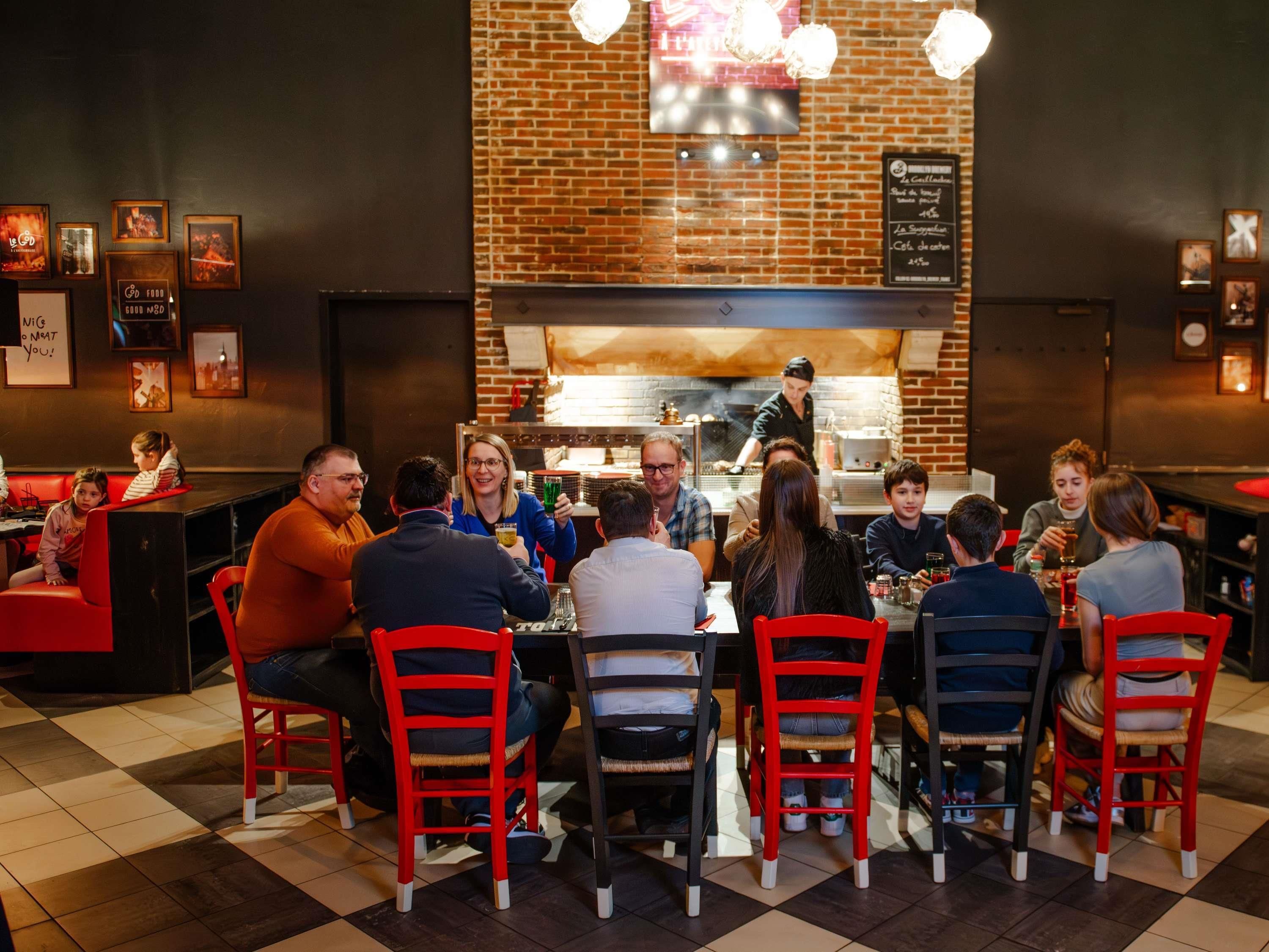 A restaurant with a brick wall, a counter, and a group of people dining.