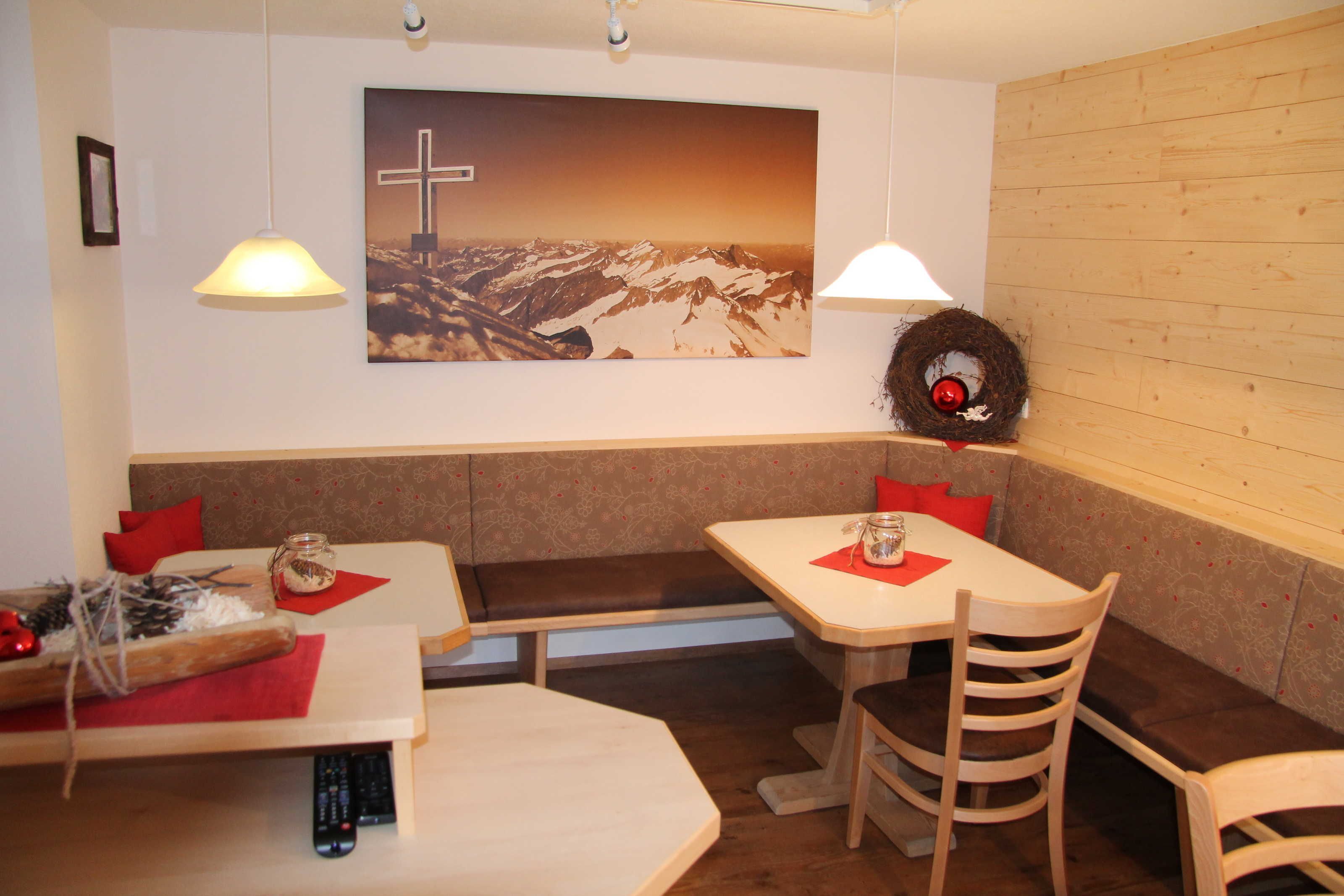 A restaurant with wooden walls, a cross painting, and a wreath on the wall.