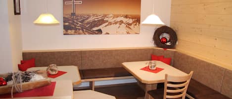 Un restaurante con paredes de madera, un cuadro de una cruz y una corona decorativa en la pared.