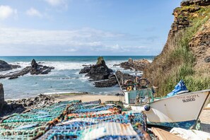 A rocky coastline with a boat named 'SILENCI' anchored near the shore.