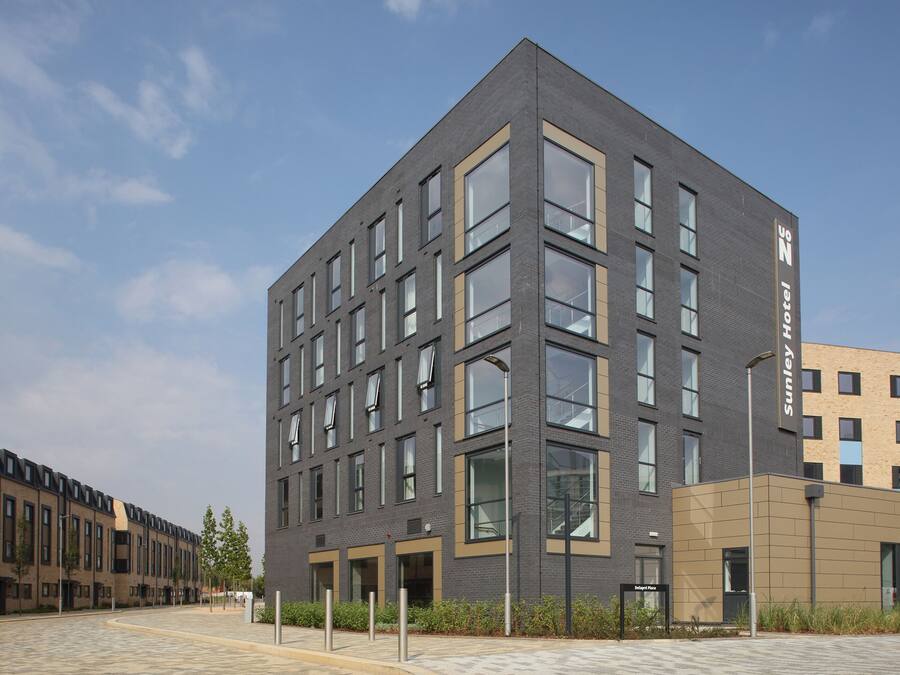 A modern hotel building with a flat roof, multiple windows, and a clean, urban design.